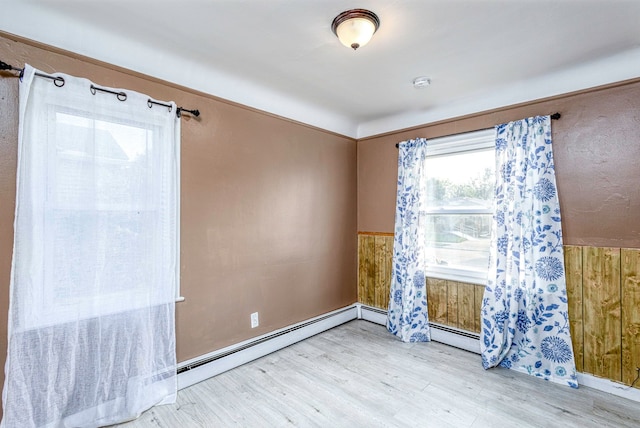 spare room with wooden walls and light hardwood / wood-style flooring