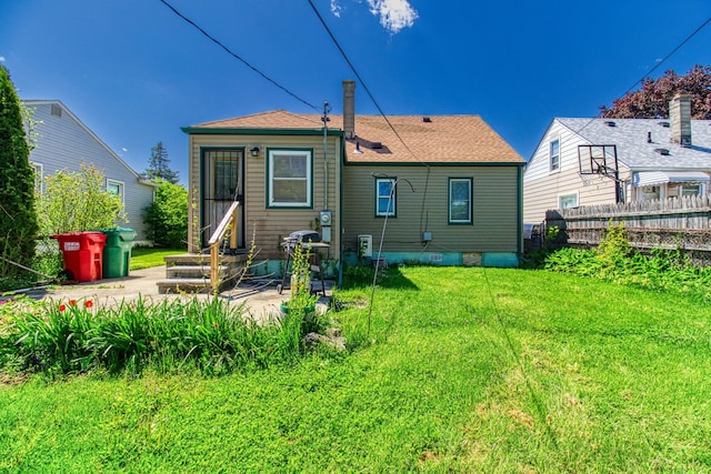 rear view of property featuring a lawn and a patio