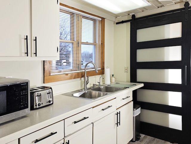 kitchen featuring white cabinetry, sink, and hardwood / wood-style floors