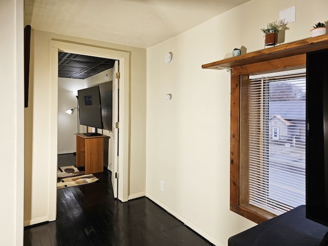 hall with a textured ceiling and dark hardwood / wood-style floors