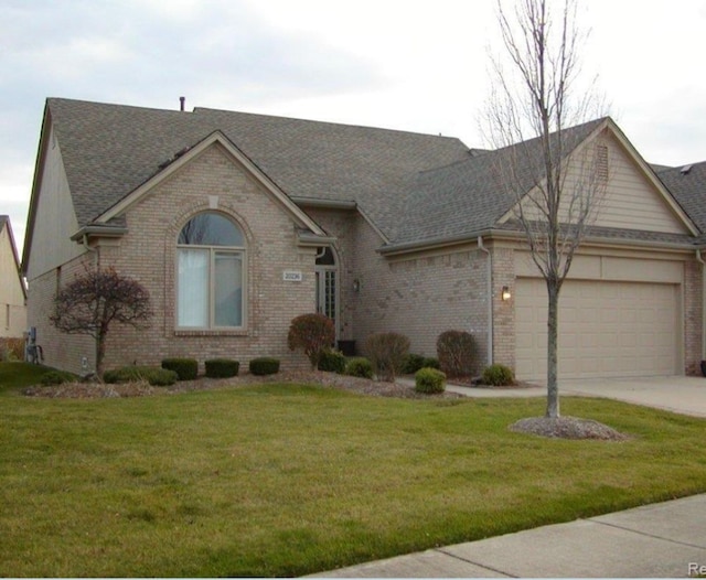 ranch-style house featuring a front lawn and a garage