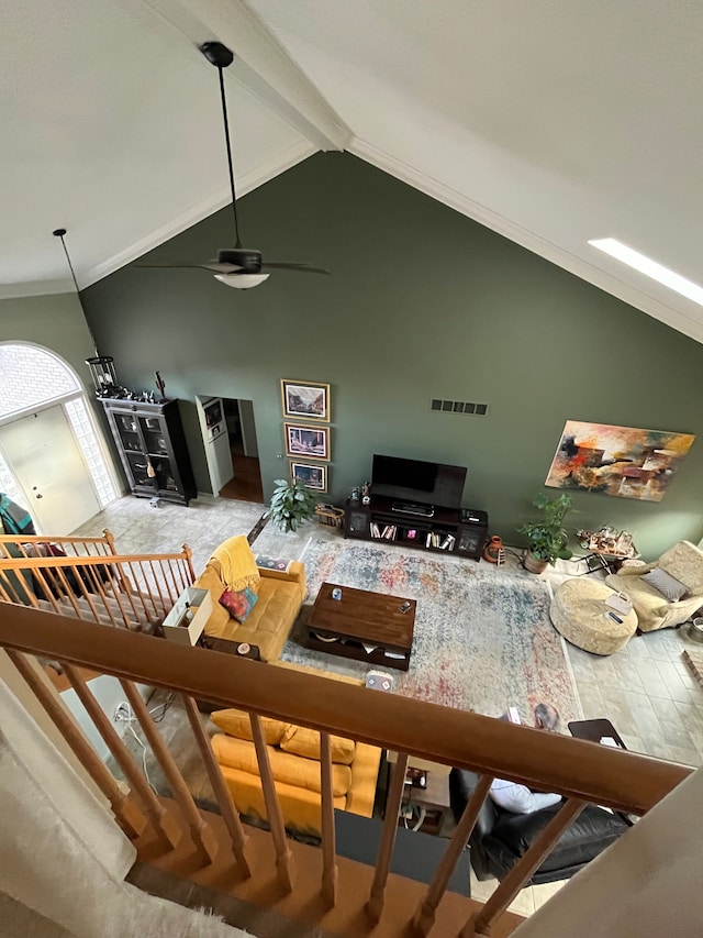 living room featuring ceiling fan, beam ceiling, ornamental molding, and high vaulted ceiling