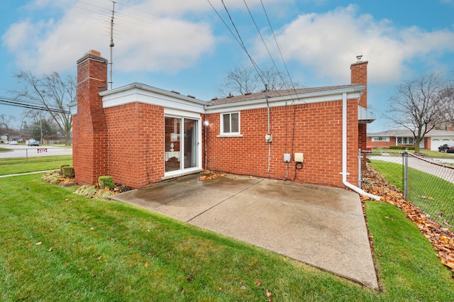 rear view of house featuring a patio area and a lawn