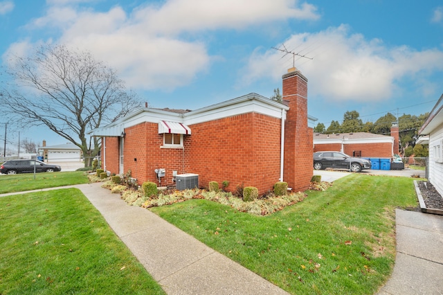 view of side of home featuring central AC unit and a lawn