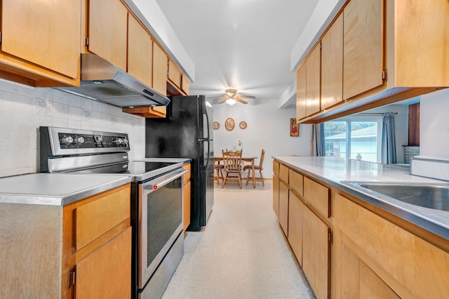 kitchen featuring light brown cabinetry, backsplash, stainless steel range with electric stovetop, ceiling fan, and range hood