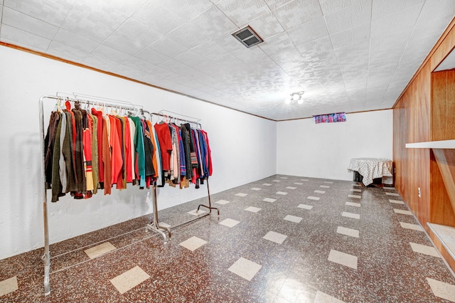 interior space featuring wood walls and ornamental molding