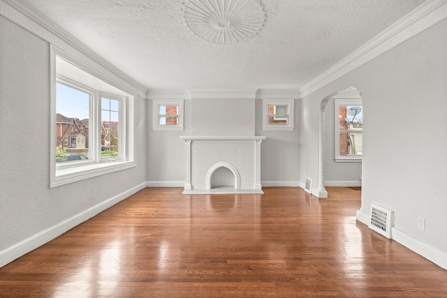 unfurnished living room with crown molding, a textured ceiling, and hardwood / wood-style flooring