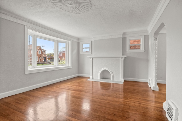 unfurnished living room featuring hardwood / wood-style floors, a textured ceiling, and crown molding