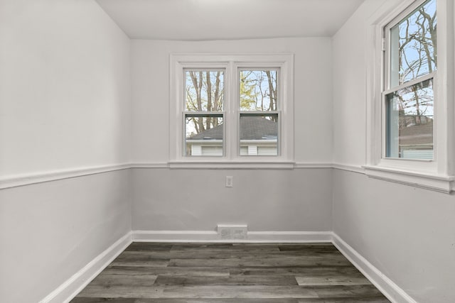 unfurnished room featuring plenty of natural light and dark hardwood / wood-style floors