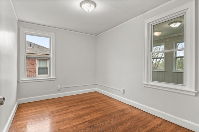 spare room with ornamental molding and hardwood / wood-style flooring