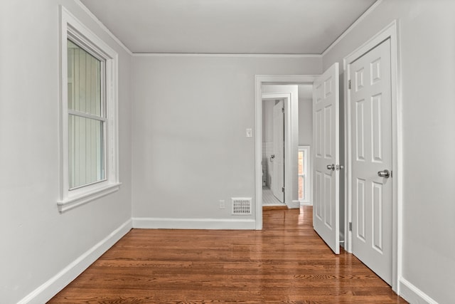 spare room with dark hardwood / wood-style flooring and ornamental molding