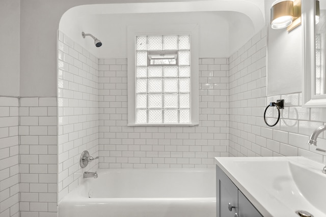 bathroom featuring vanity, tiled shower / bath combo, and tile walls