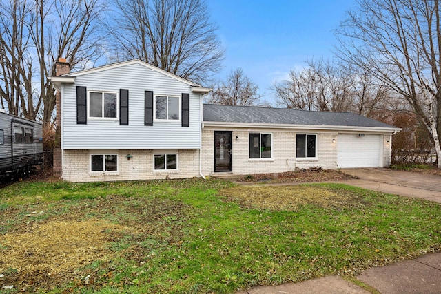 tri-level home featuring a front yard and a garage