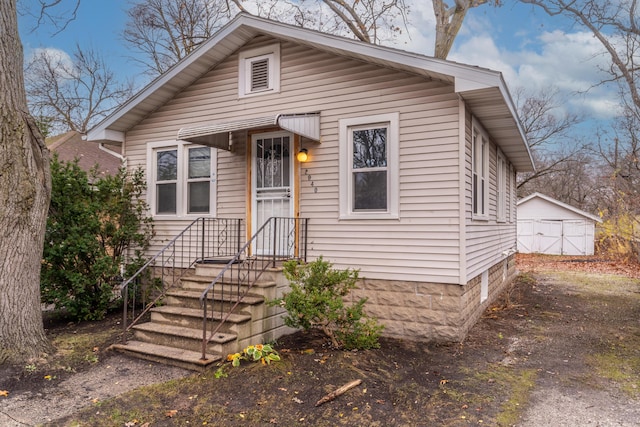 bungalow-style house featuring an outbuilding and a garage