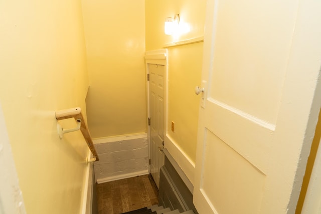 staircase featuring wainscoting and wood finished floors