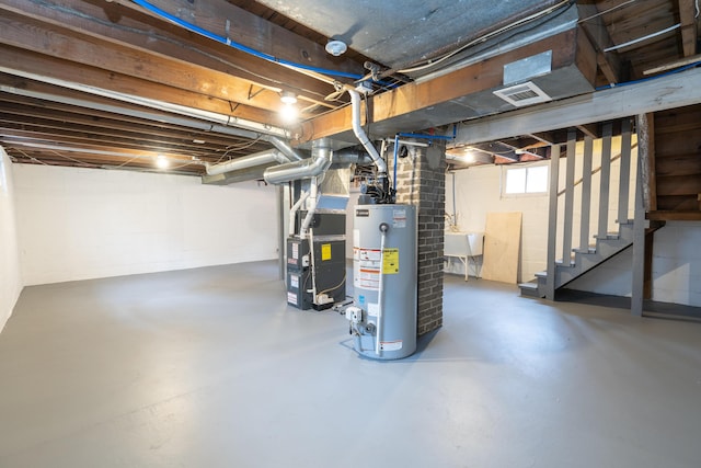 below grade area featuring visible vents, heating unit, stairs, water heater, and a sink