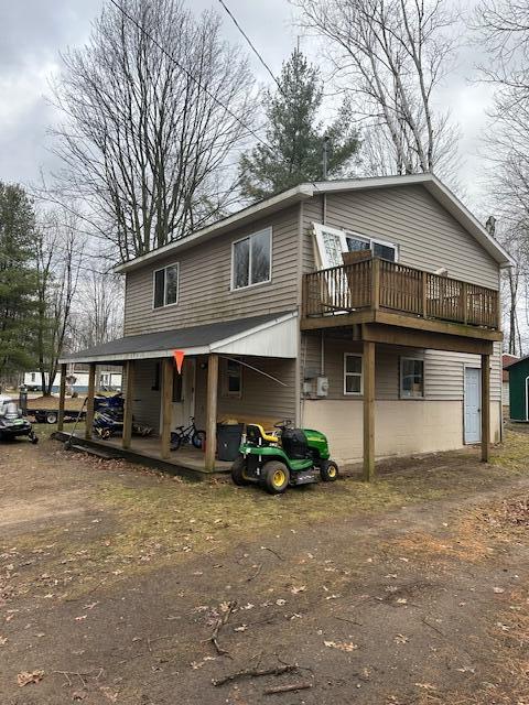 back of house featuring a shed and a wooden deck