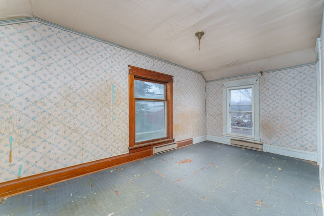 spare room featuring lofted ceiling and a baseboard heating unit