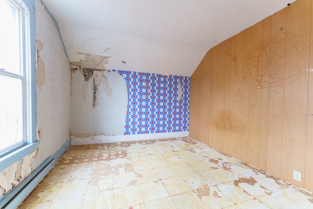 additional living space with a baseboard radiator and vaulted ceiling