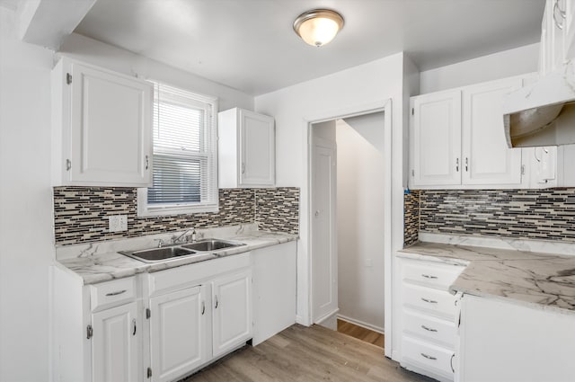 kitchen with light hardwood / wood-style floors, white cabinetry, and tasteful backsplash