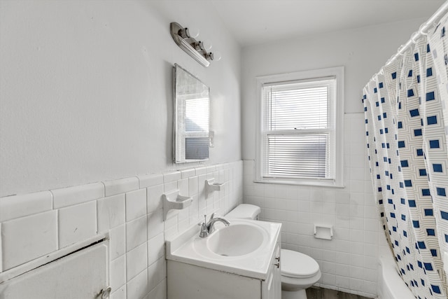 full bathroom with shower / tub combo, vanity, toilet, and tile walls