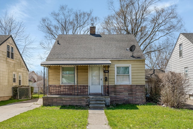19300 Woodside St, Harper Woods, MI 48225 - view of front of home with a chimney, covered porch, a front yard, and a shingled roof