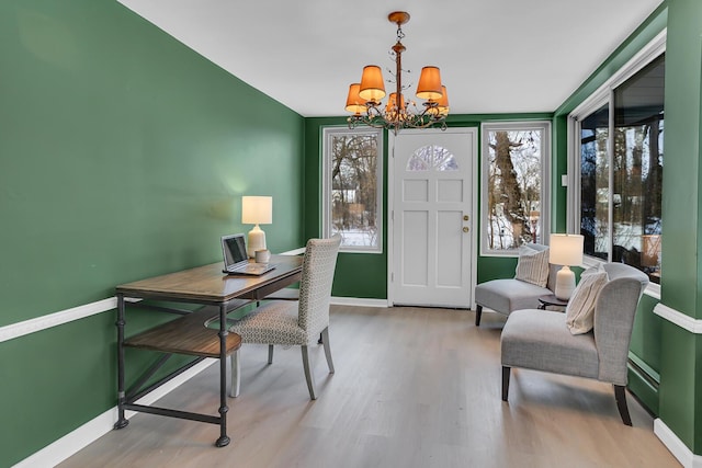 office area with light hardwood / wood-style flooring and a chandelier