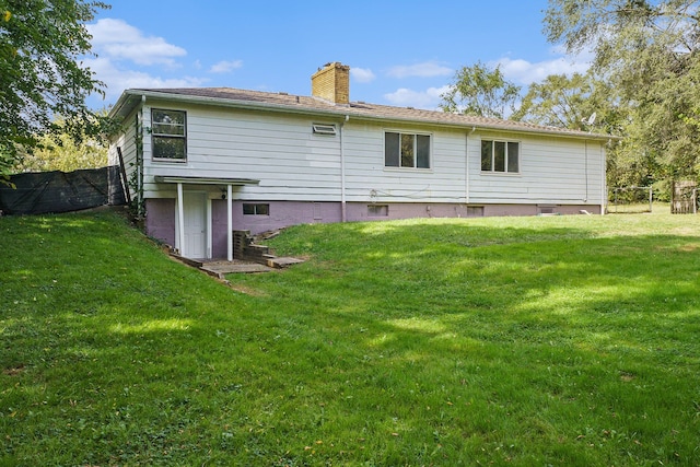 rear view of property with a lawn