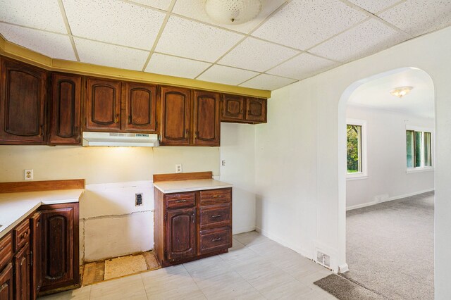 3085 S Center Rd, Burton, MI 48519 - kitchen with under cabinet range hood, a paneled ceiling, arched walkways, and light countertops