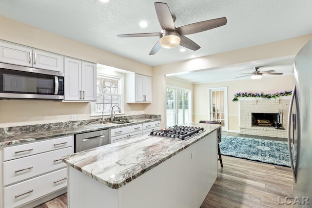 kitchen featuring plenty of natural light, a center island, light wood-type flooring, and appliances with stainless steel finishes