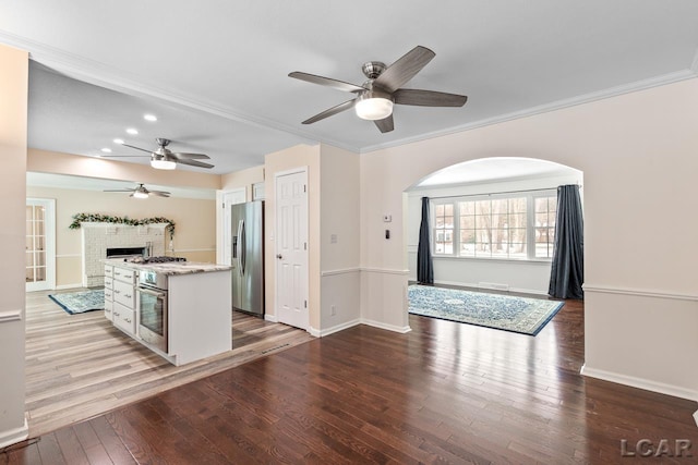 kitchen with appliances with stainless steel finishes, hardwood / wood-style flooring, white cabinetry, and ceiling fan