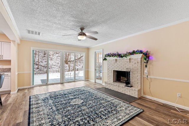 living room with hardwood / wood-style floors, a textured ceiling, ceiling fan, and crown molding