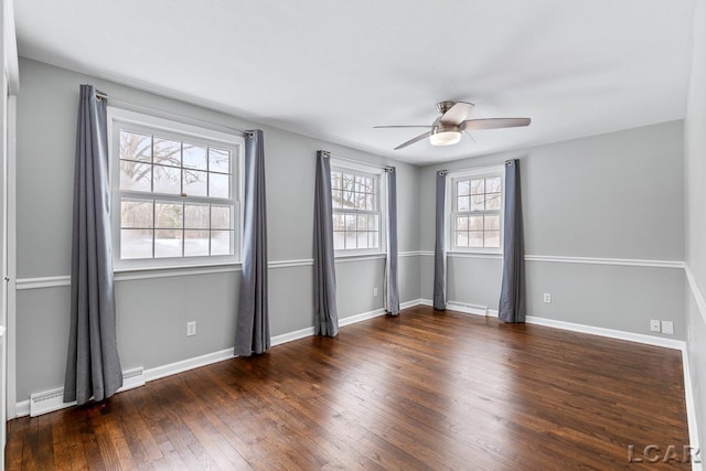 empty room featuring ceiling fan, dark hardwood / wood-style flooring, a healthy amount of sunlight, and a baseboard radiator