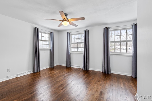 empty room featuring ceiling fan, dark hardwood / wood-style floors, and a baseboard heating unit