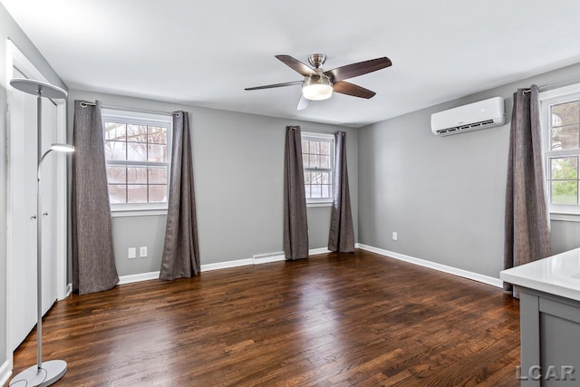 interior space with ceiling fan, a baseboard heating unit, dark wood-type flooring, and a wall mounted AC