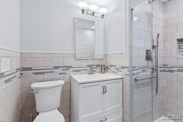 bathroom with vanity, toilet, and tile walls