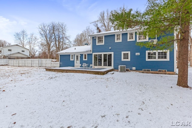 snow covered property with a deck and central AC unit