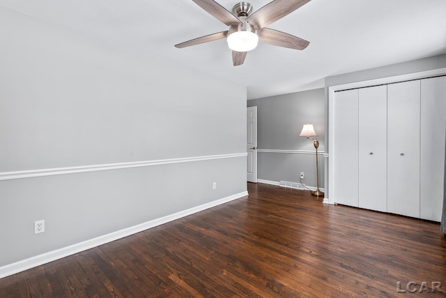 unfurnished bedroom featuring a closet, dark hardwood / wood-style floors, and ceiling fan