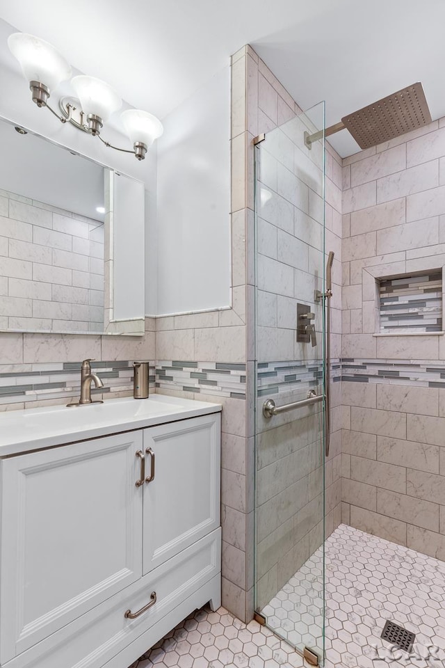 bathroom with vanity, tile patterned floors, a shower with shower door, and backsplash