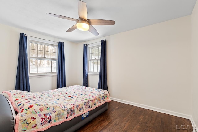 bedroom with ceiling fan, dark wood-type flooring, and multiple windows