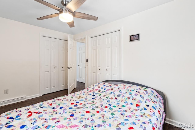 bedroom with multiple closets, ceiling fan, dark hardwood / wood-style flooring, and a baseboard radiator