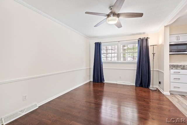 spare room featuring ceiling fan, dark wood-type flooring, and ornamental molding