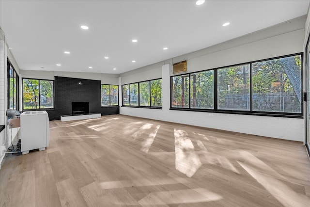 unfurnished living room with a large fireplace and brick wall