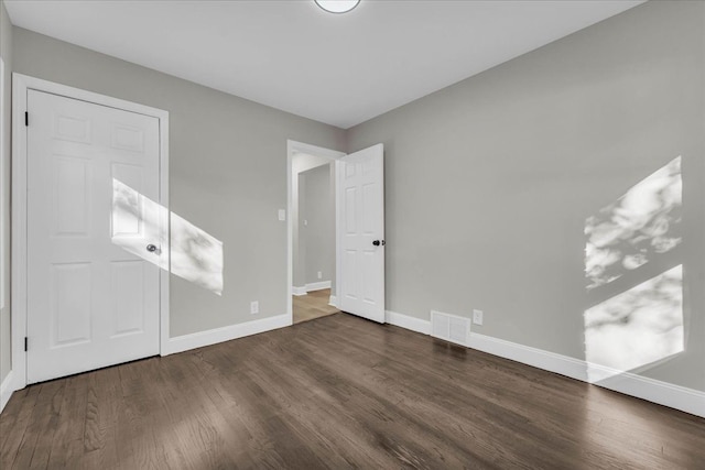 unfurnished bedroom with dark wood-type flooring