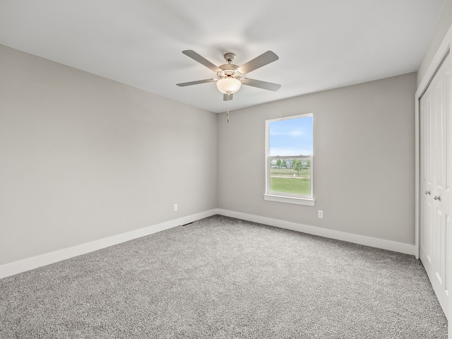 unfurnished bedroom featuring carpet flooring, ceiling fan, and a closet