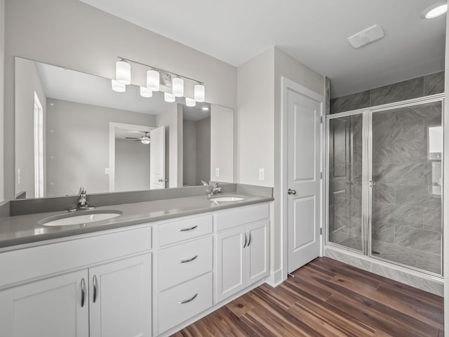 bathroom with walk in shower, ceiling fan, vanity, and hardwood / wood-style flooring