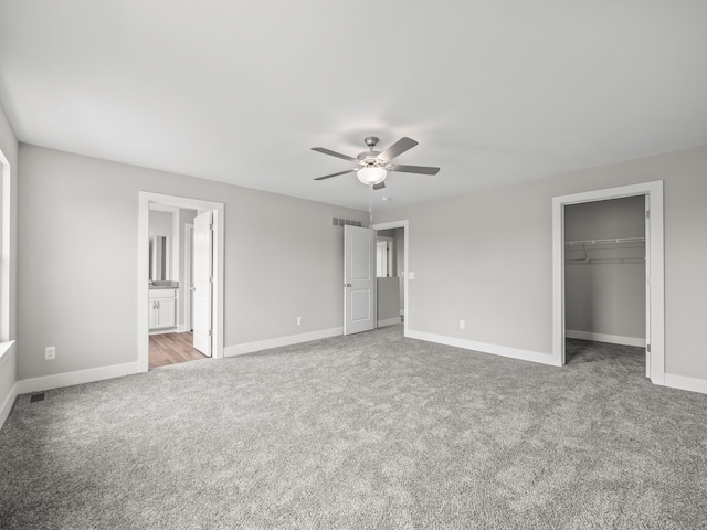 unfurnished bedroom featuring connected bathroom, ceiling fan, a closet, and carpet floors