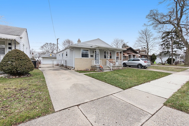 bungalow-style house with a porch, a garage, a front lawn, and an outdoor structure