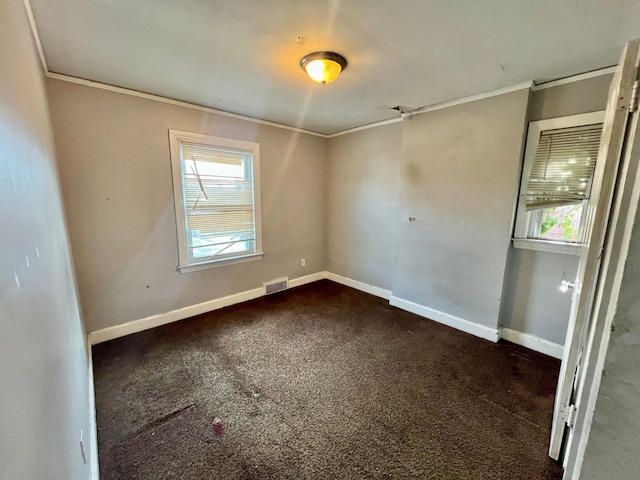 carpeted empty room featuring crown molding