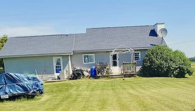 rear view of property featuring a yard and a deck